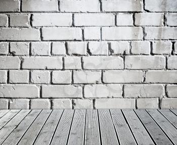 Grey brick wall with old weathered wooden floor