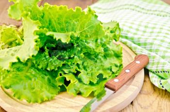 Green lettuce with a knife, napkin on wooden board