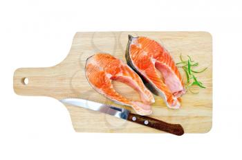 Two pieces of trout with rosemary, a knife on a wooden board isolated on white background