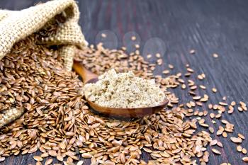 Flax flour in a spoon, seeds in a bag and on a table on the background of a wooden board