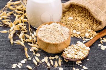 Flour oat in a bowl, grain in a bag, oatmeal in a spoon, oaten stalks on wooden board background