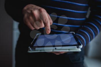 The man uses a tablet PC. Modern gadget in hand.