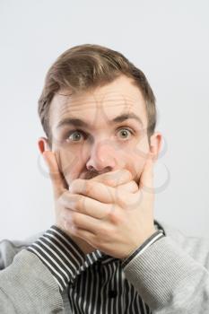 Emotional man keep his mouth closed by his hands