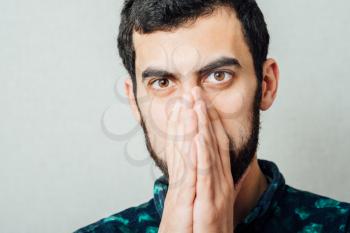 Closeup portrait of young man thinking daydreaming deeply about something with chin on hand fist looking downwards. Emotion facial expressions feelings