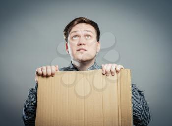 Casual young man holding a box isolated