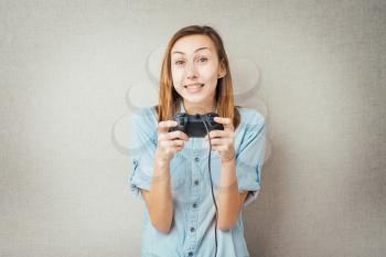 Young happy women plays a game by joystick