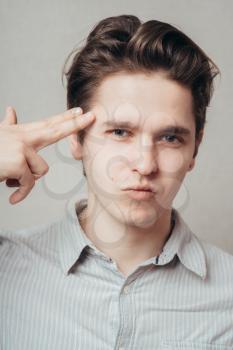 young man committing suicide with imaginary gun