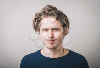 Close up portrait of a young man with a confused face