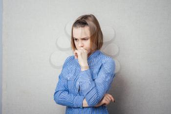 portrait of a worried young woman with a pensive gesture