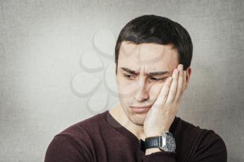 a young man upset with hand on face