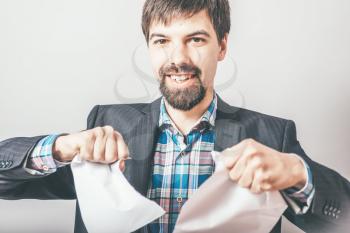 bearded businessman rips paper