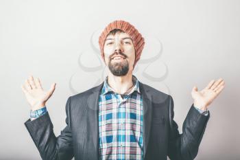 businessman throws up his hands with a beard and wearing a hat