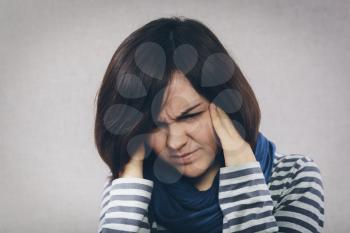 yuong woman holding head in pain over white background