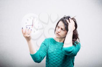 Shocked woman holding office clock