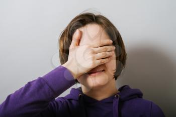 girl covers her face from the photographer, camera