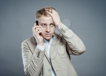 Closeup portrait, young man annoyed, frustrated, pissed off by someone listening on his mobile phone, bad news. Long wait times, horrible conversations concept