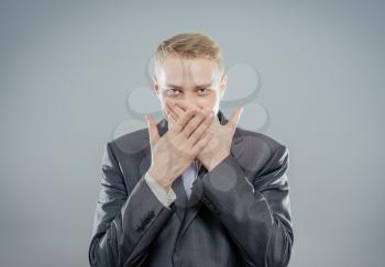 Emotional man keep his mouth closed by his hands