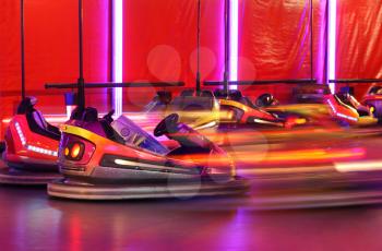 Bumper cars in motion in amusement park