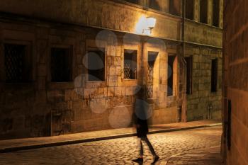 Girl silhouette in motion on night illuminated street in Europe
