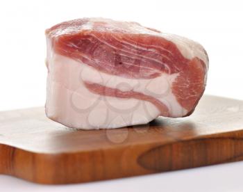 a piece of fresh salty pork on a cutting board