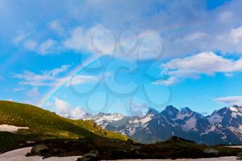Royalty Free Photo of a Rainbow Over Mountains