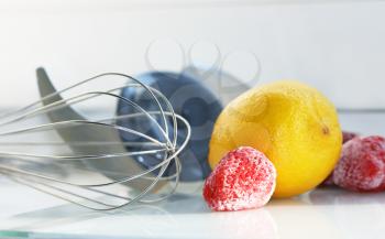 Royalty Free Photo of a Whisk, Lemon, and Strawberries