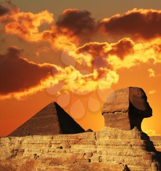 Royalty Free Photo of an Egyptian Sphinx and Pyramid at Sunset