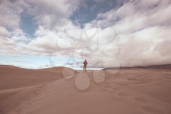 Hiker among sand dunes in the desert