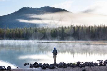 Hiker relaxing at serene mountain lake