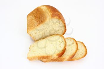 The ruddy long loaf of bread with the fried crust is isolated on a white background