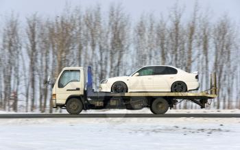 The wrecker carries the car of white color