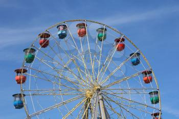 Atraktsion colorful ferris wheel against the blue sky