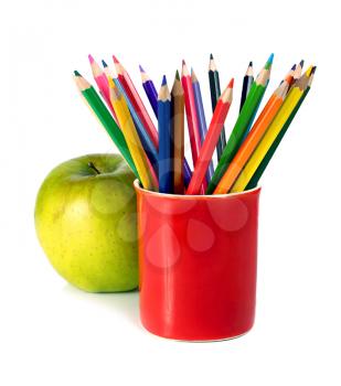 crayons coloured pencils and green apple isolated on white background