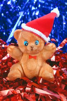 toy bear in the hat of santa claus on red and blue background