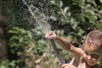 boy squirting water from a hose