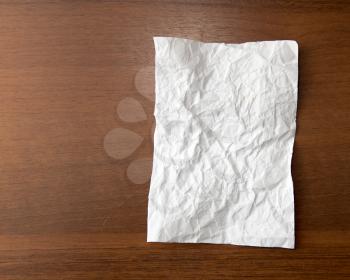 crumpled white paper on the wooden background