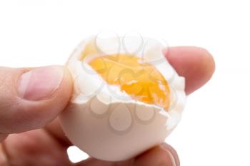egg with yolk in a hand on a white background
