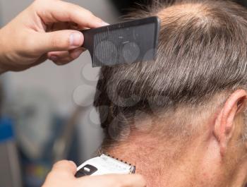 Close up of a male student having a haircut with hair clippers