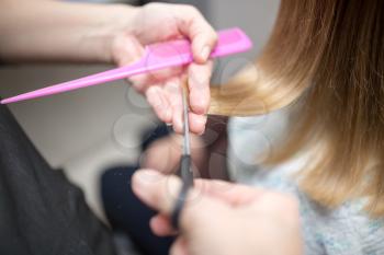 Female hair cutting scissors in beauty salon