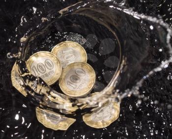 coins in water splashes on a black background