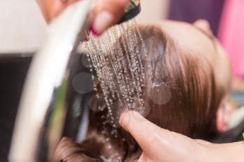 Hairstylist washing woman hair. Hairdressing beauty salon