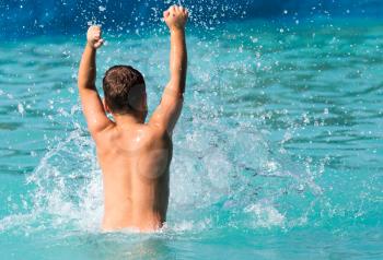 boy swims with a splash in the water park