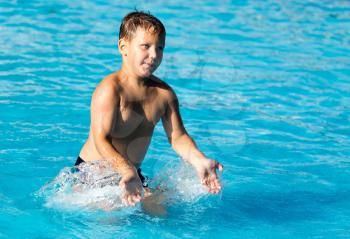 boy swims with a splash in the water park