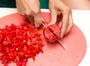 girl cuts a tomato knife