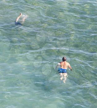 man bathes in the lake on the beach