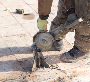 Worker cuts metal in the park