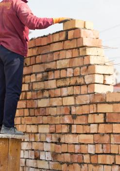 Worker builds a brick wall in the house .