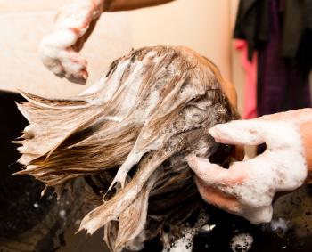 Wash a woman's head in a beauty salon .