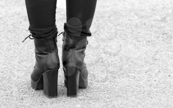 Legs of a girl in black heels .