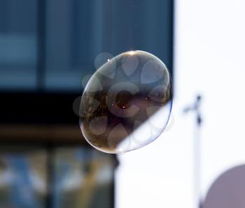 Beautiful soap bubbles fly in the city .
